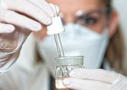 Laborantin mit Mund-Nasen-Schutz im Labor