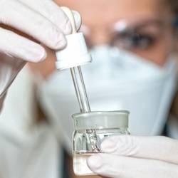 Laborantin mit Mund-Nasen-Schutz im Labor