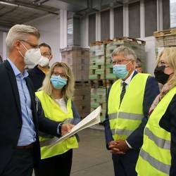 Der neue Geschäftsführer der GGP Media GmbH, Sven Isecke (links), erklärt Landrat Thomas Fügmann (Mitte) und seiner Delegation bei einem Rundgang die wichtigsten Arbeitsschritte bei der Herstellung von Büchern.