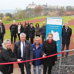 Kompletterneuerte Schulsportanlage in Ranis eingeweiht © Alexander Hebenstreit / Landratsamt Saale-Orla-Kreis Im Beisein von Landrat Thomas Fügmann, Sportlehrerin Gabriele Baderschneider (vorn Mitte) und weiteren Beteiligten war es den beiden Schulleiterinnen Christina Groß (vorn links) und Janine Scheller vorbehalten, das rote Band am neuen Zugang zum Sportplatz zu durchschneiden.