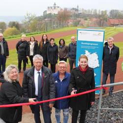 Im Beisein von Landrat Thomas Fügmann, Sportlehrerin Gabriele Baderschneider (vorn Mitte) und weiteren Beteiligten war es den beiden Schulleiterinnen Christina Groß (vorn links) und Janine Scheller vorbehalten, das rote Band am neuen Zugang zum Sportplatz zu durchschneiden.