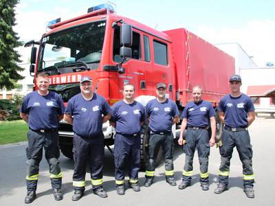 Sechs Feuerwehrleute vor Fahrzeug Dekon P