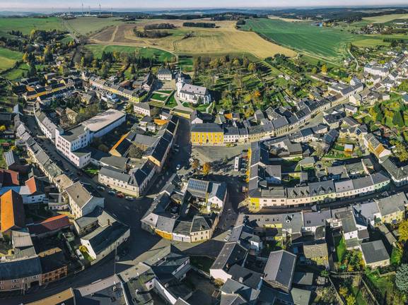 Die Stadt Tanna mit ihren 13 Ortsteilen liegt im südöstlichen Teil des Freistaats Thüringen, im Dreiländereck an der sächsisch-bayerischen Grenze, inmitten des wundervollen Thüringer Waldes. Ein Besuch dieser reizvollen Gegend lohnt immer – ganz egal ob man auf den Spuren des „Gelehrten Bauern“ in Rothenacker wandeln, den sagenumwobenen „Stelzenbaum“ besuchen oder einfach nur die Seele im Naherholungsgebiet Leitenteiche südlich der Kernstadt baumeln lassen möchte.