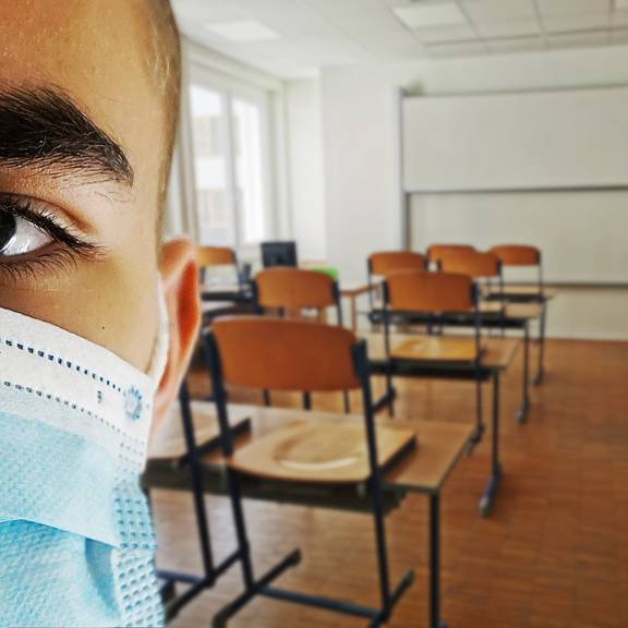 Illustration Thema Corona - Schule - Schüler mit Maske im leeren Klassenraum