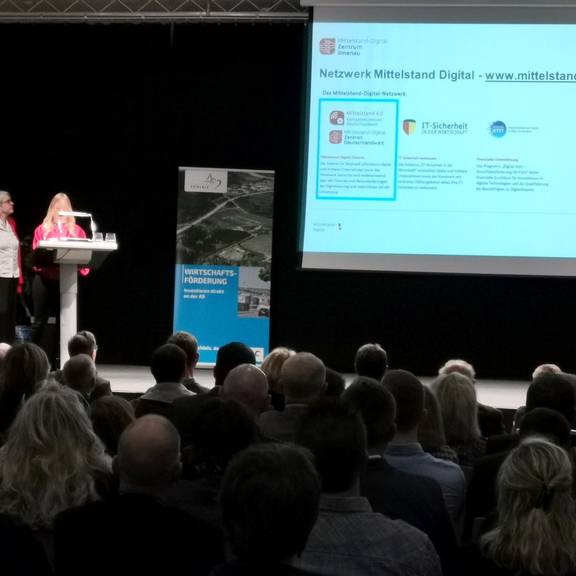 Der Blick über das Publikum hinweg zur Bühne, wo Constanze Möhwald (links) und Isabell Weiß mithilfe einer Power Point-Präsentation zum Thema Digitalisierung referieren.