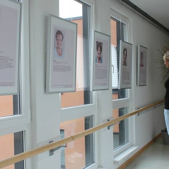 Ein Frau betrachtet eines der Plakate der Ausstellung zu den Schicksalen von in der DDR geschiedenen Frauen.